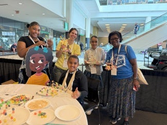 Students and teachers pose with Deja the Dynamo.