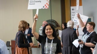 Woman holding up a sign at AIA conference