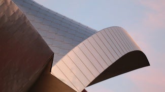 Bronze building in front of pink sky