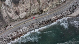 aerial view of pacific coast highway with fire damage on ocean side