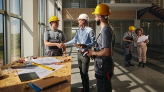 Group of architects talking about a project while at a construction site